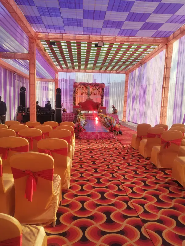 Banquet tent with orange seating and a decorated stage